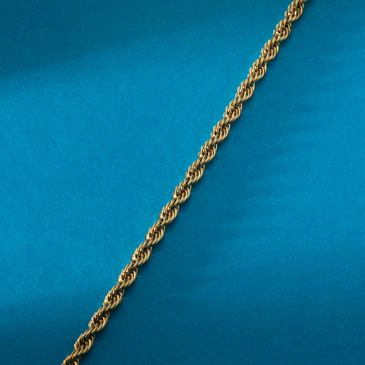 стомана със златно PVD, структура на усуканата верижка (rope), Morellato, макро на син фон