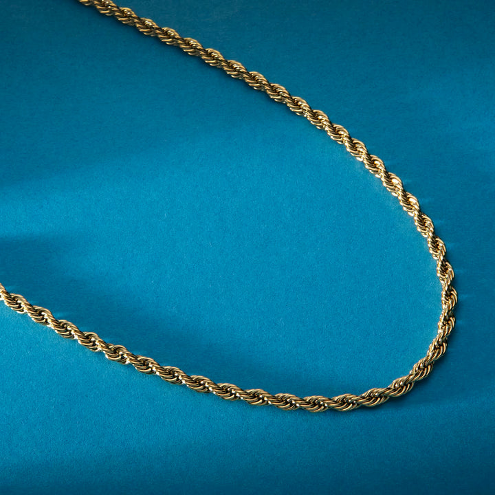 стомана със златно PVD, колие Intrecci, Morellato, на син/студиен фон