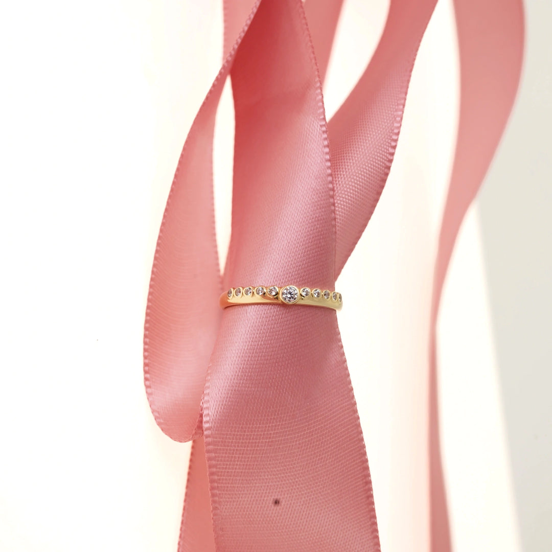 Дамски златен пръстен с циркони върху панделка.