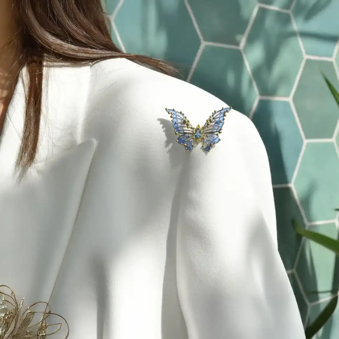Сребърна брошка пеперуда със син емайл върху сако – лайфстайл визия