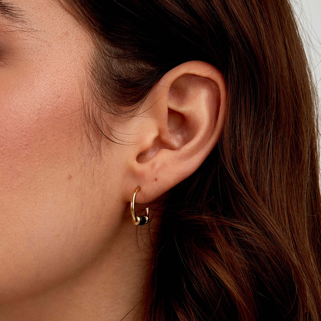 Стилни дамски обеци от стомана със златно PVD покритие, декорирани с бели цилиндрични елементи. SAXQ11. Размер 17 мм.