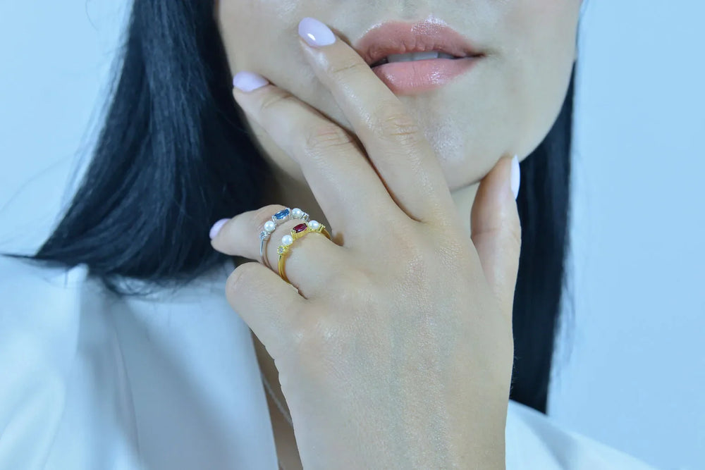 Детайлен кадър на дамски пръстен Salvatore Plata с перли и син топаз на ръка.