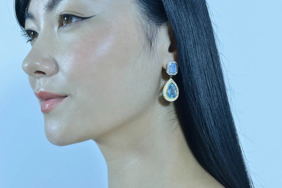 Дамски обеци Salvatore Plata с аквамарин, носени от жена с тъмна коса.