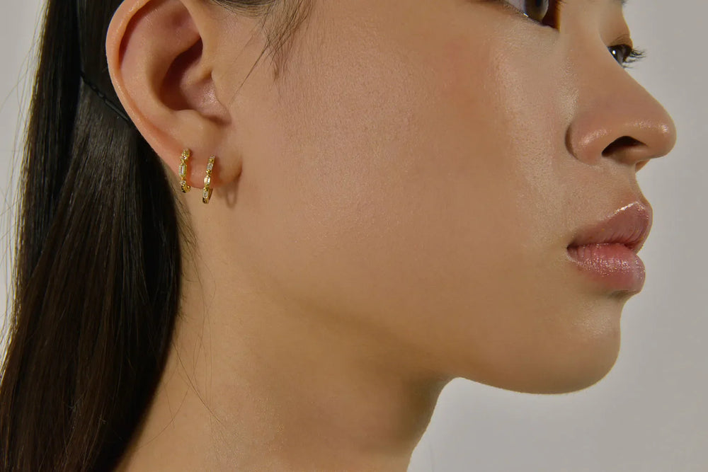 Профил на жена, носеща сребърни обеци Salvatore Plata с бели циркони.