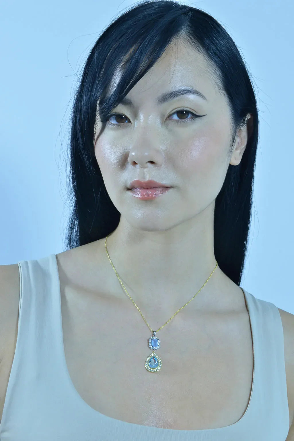 Момиче носи елегантно сребърно колие Salvatore Plata с аквамарин и топаз.