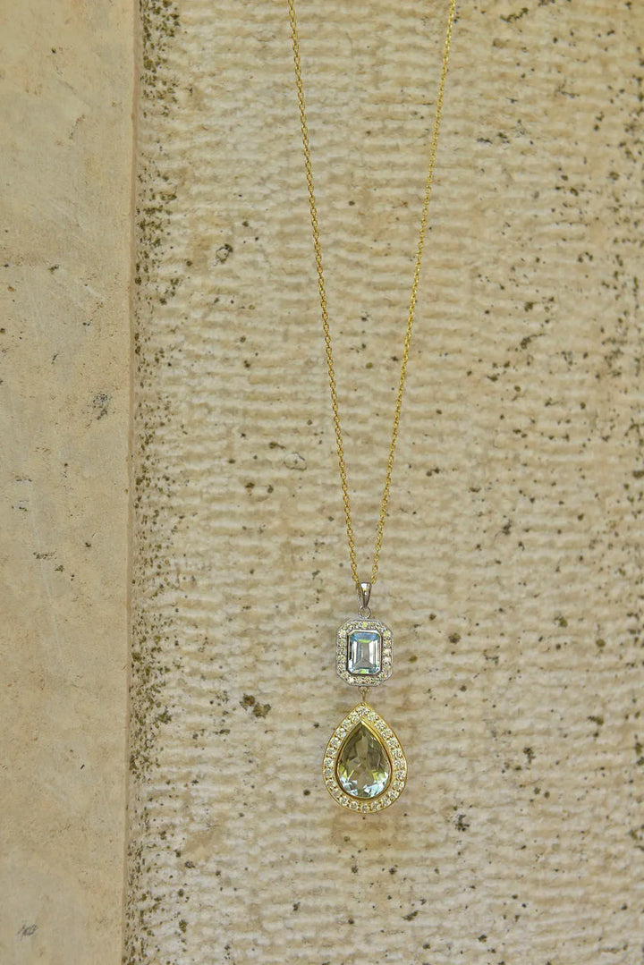 Сребърно колие Salvatore Plata с аметист и топаз, поставено на текстурирана повърхност.