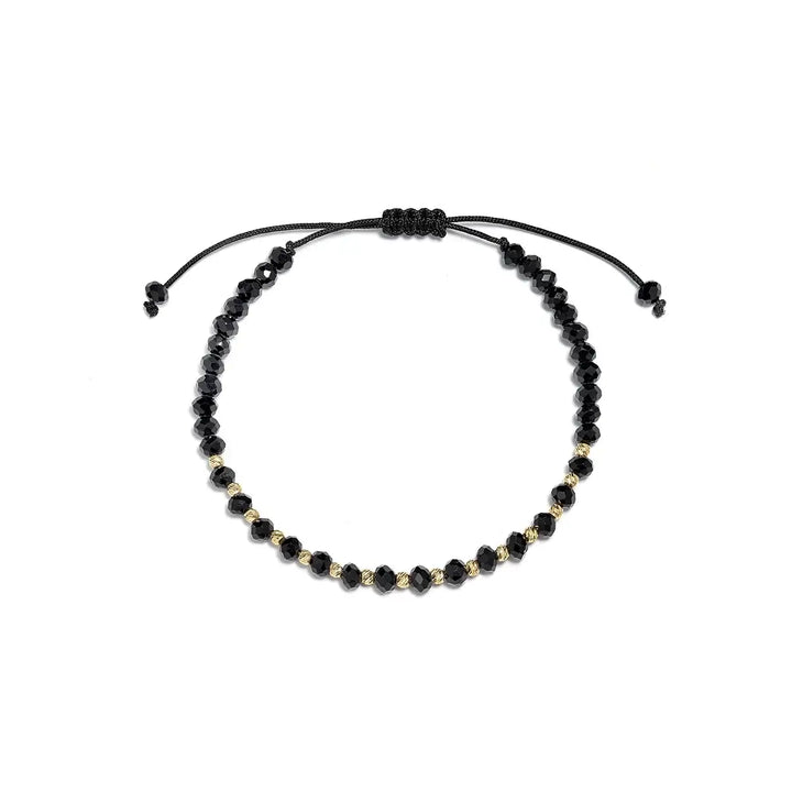 Гривна с черни мъниста и златни акценти върху текстилна връзка