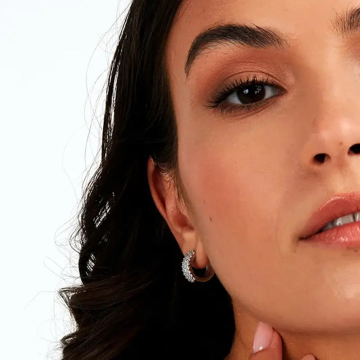 Сребърни халки с циркони върху ухо на модел, елегантна визия.