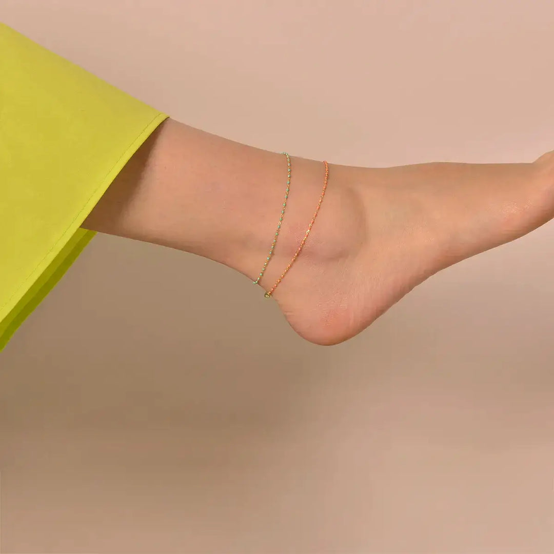 Модел носи позлатена сребърна гривна за крак и глезен с ментови мъниста от колекция Minijewels