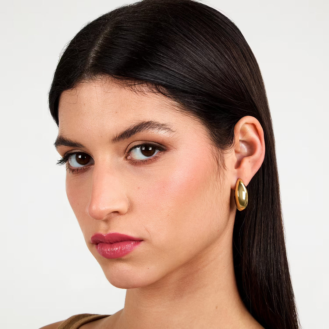Позлатени обеци халки от медицинска стомана върху ухо, портрет на модел, Morellato SAUP32.
