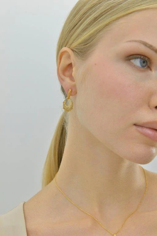 Gold-plated silver earrings with interwoven lines and Paraiba-colour CZ Salvatore Plata — worn on a model