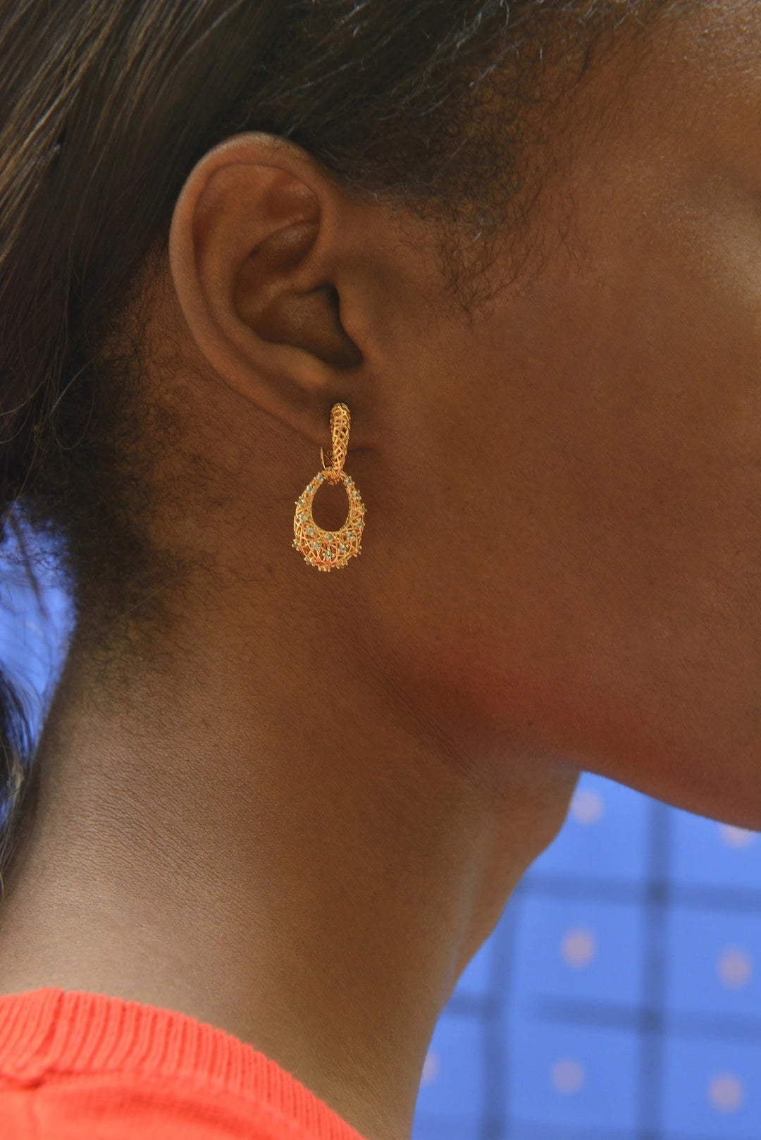 Gold-plated silver earrings with interwoven lines and Paraiba-colour CZ Salvatore Plata — worn on a model