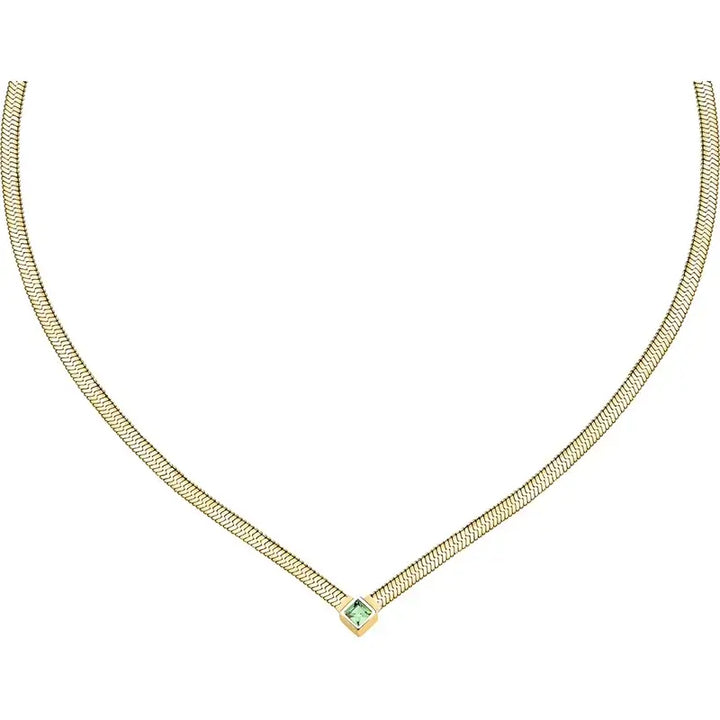 Лайфстайл кадър на златисто колие със зелен кристал на цветен фон.