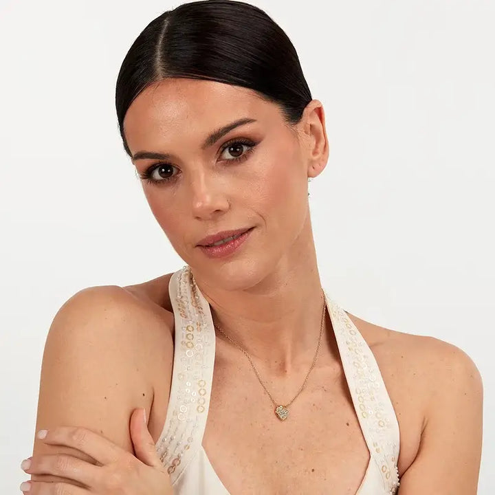 Позлатено колие сърце с кристали върху шия на модел – портрет.