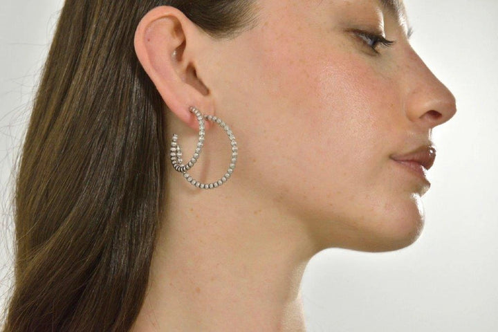 Silver hoop earrings with satin-finished spheres Salvatore Plata — worn on a model