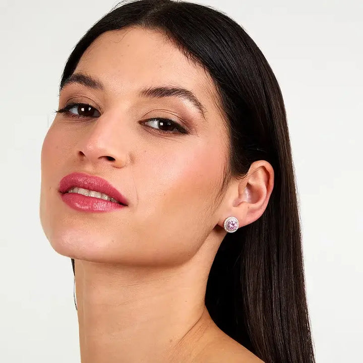 Сребърни обеци „ореол“ с розов циркон върху ухо на модел, портрет.