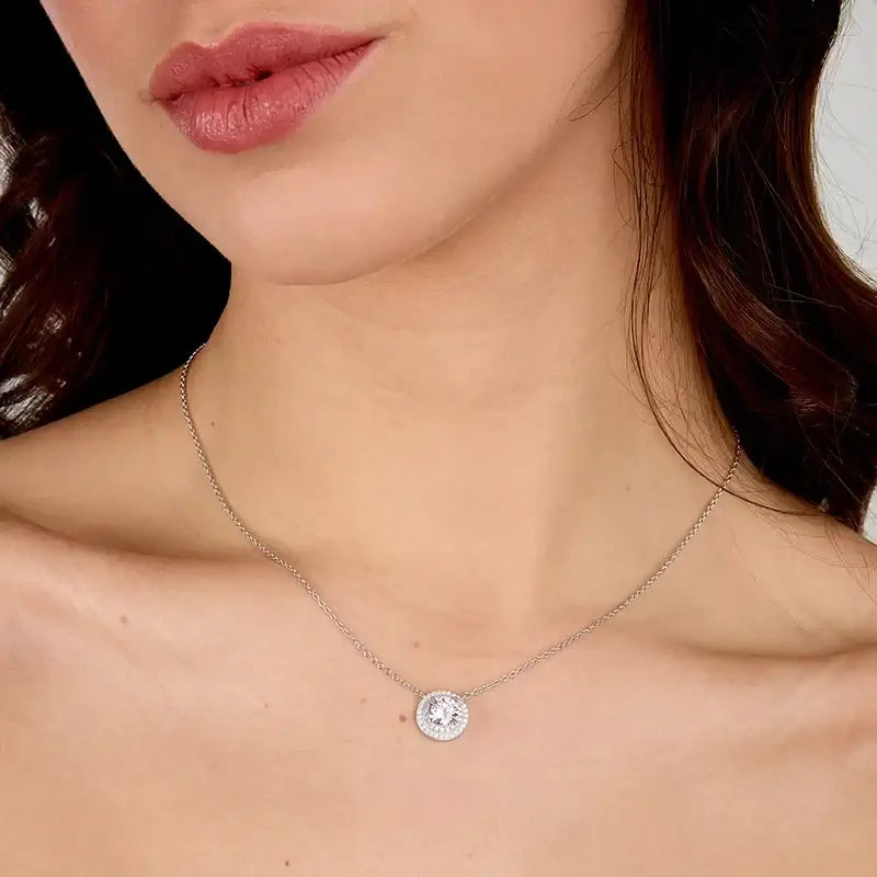 Близък план на висулка с розов циркон и бели циркони на врата.