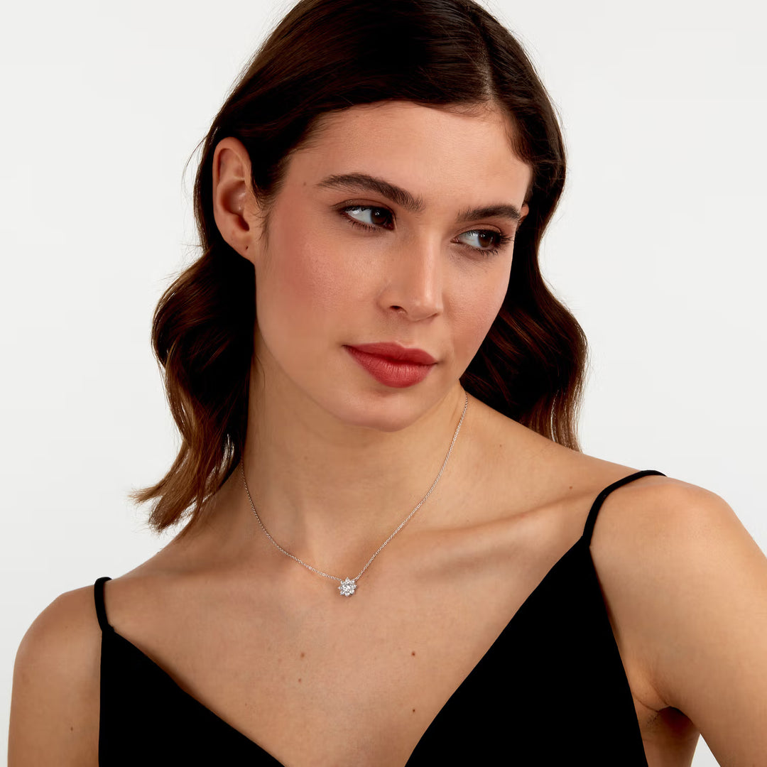 Родирано сребърно колие с цвете и циркони върху шия на модел, портрет.